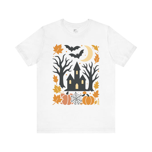 White t-shirt with Halloween-themed design featuring a castle, trees, pumpkins, and bats on a white background.