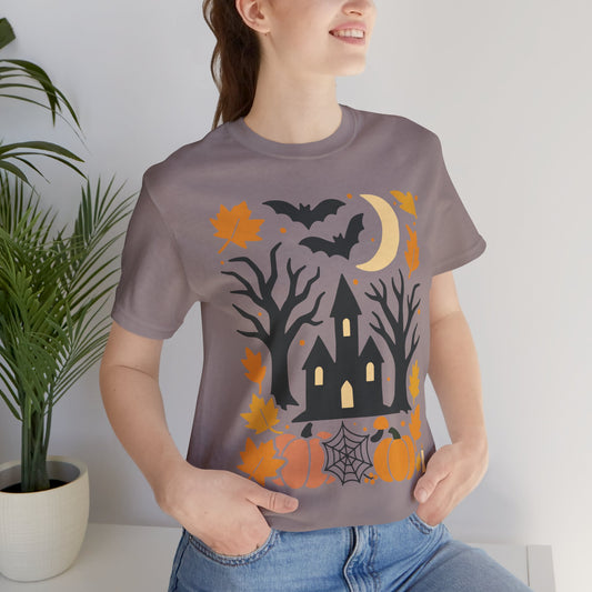 Unisex t-shirt with a haunted house, pumpkins, bats, and full moon Halloween graphic.